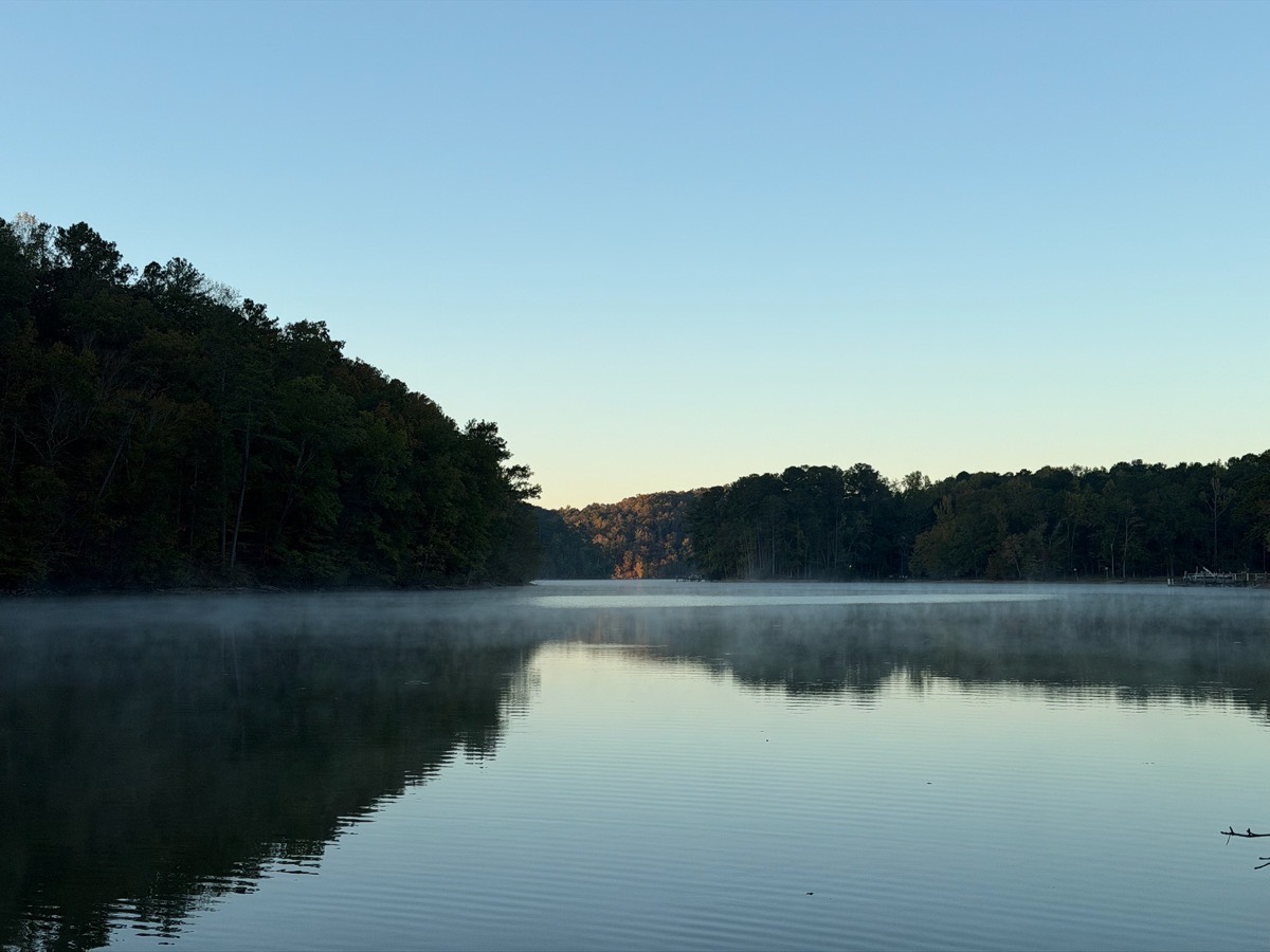Morning mist rising over the lake with fall foliage